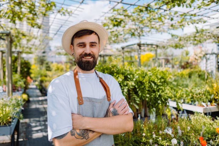 Proud Gardener Enjoys A Sunny Day In The Greenhouse