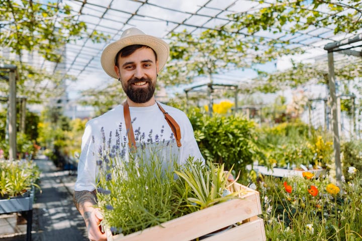 Joyful Gardener Tending to Greenhouse Plants in Spring