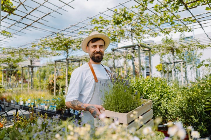 Joyful Gardener Tends to Vibrant Greenhouse on Sunny Day
