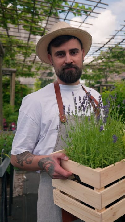 Gardener Embraces the Greenhouse's Vibrant Growth