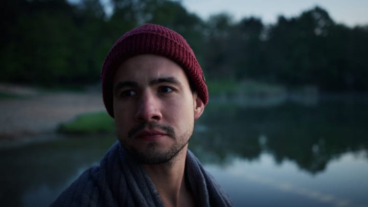 Man In Red Beanie Gazes Across Chilly Lake
