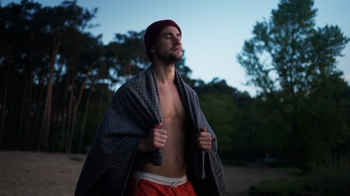 Man Embraces Serenity After Cold Water Swim In Nature