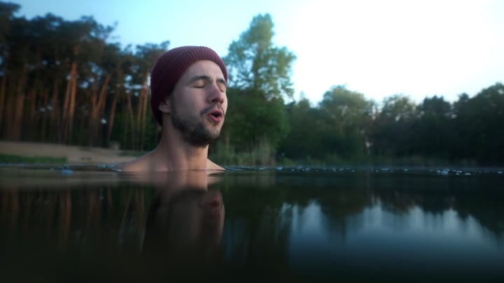 Embracing the Chill: Man's Tranquil Swim at Dawn