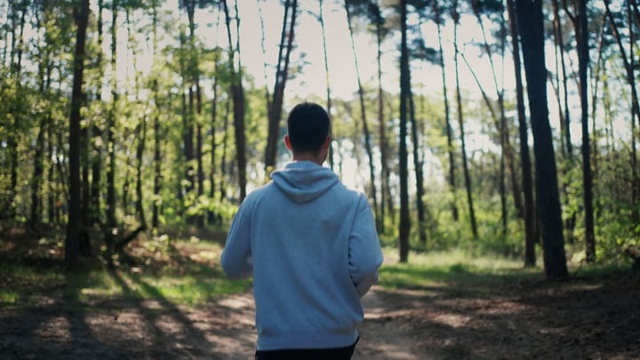 Man Embraces Tranquility During Forest Walk In Autumn