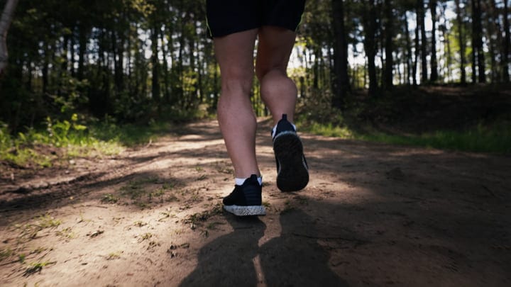 A Runner Embraces the Tranquility of a Sunlit Forest Path