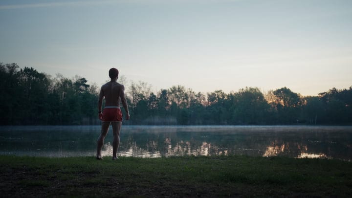Man Stands at Misty Lake Before Cold Water Swim
