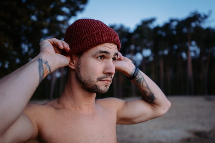 Man Adjusts Beanie Before Cold Water Swim Adventure