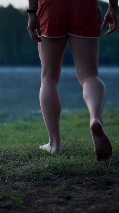 Barefoot Adventurer Approaches the Icy Lake’s Edge