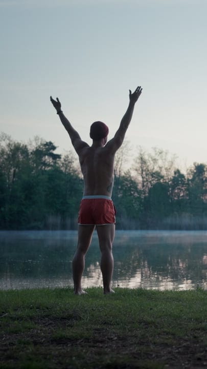 Embracing Dawn's Chill With Open Arms By The Lake