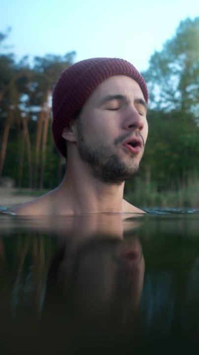 Embracing The Chill: Man Immersed In Cold Water Serenity
