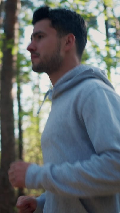 A Man Embraces Nature During a Jog in the Woods
