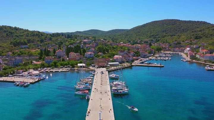 Sailboats Docked in a Serene Turquoise Bay Village