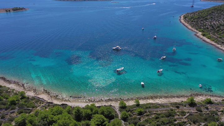 Sailboats Gracefully Drift In Turquoise Bay's Splendor