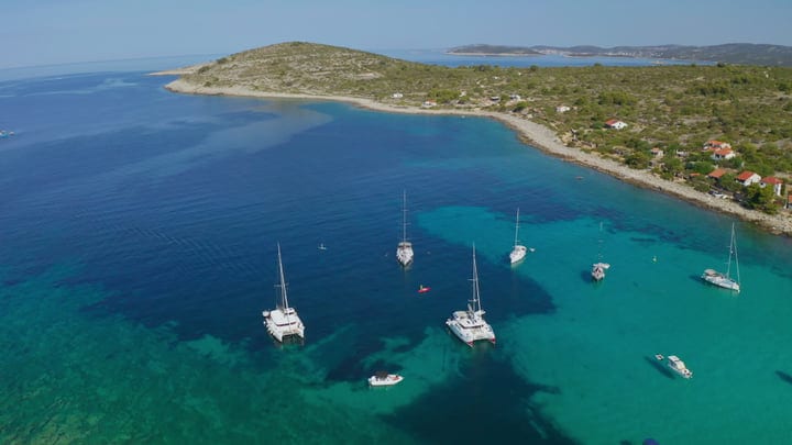 Sailboats Drift in Tranquil Turquoise Bay Waters