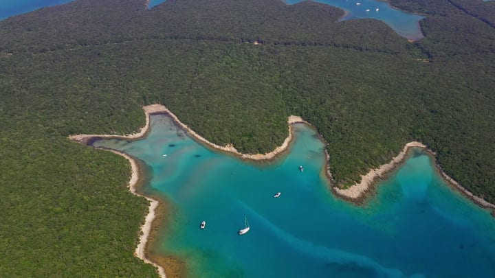 Sailboats Drift Serenely In A Hidden Turquoise Bay