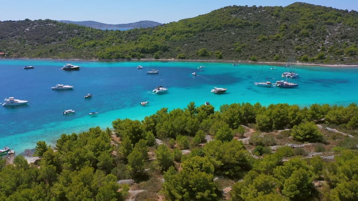 Aerial View Of Sailboats In A Serene Turquoise Bay