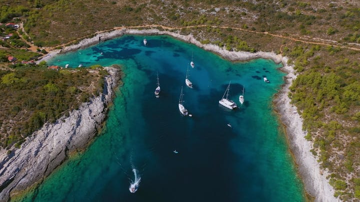 Sailboats Gracefully Anchor In Turquoise Mediterranean Bay