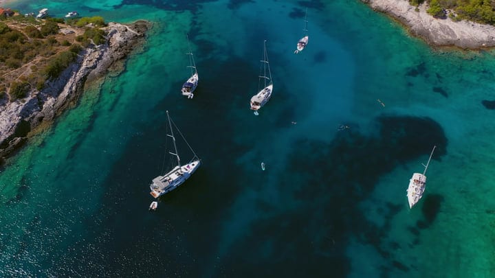 Sailboats Gracefully Drift In A Serene Turquoise Bay