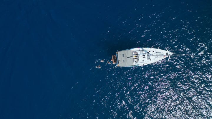Sailboat Adrift In Glittering Turquoise Waters