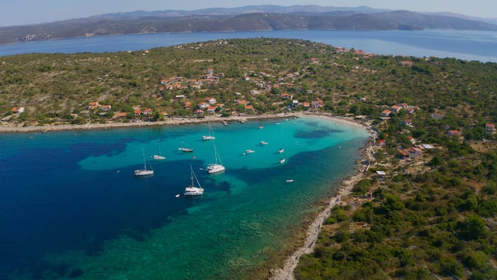 Sailboats Gracefully Anchor In Serene Turquoise Bay