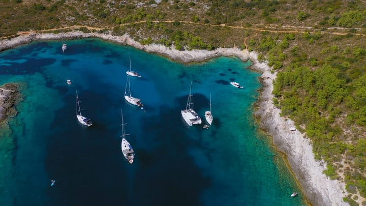Sailboats Gracefully Drift In A Serene Turquoise Bay