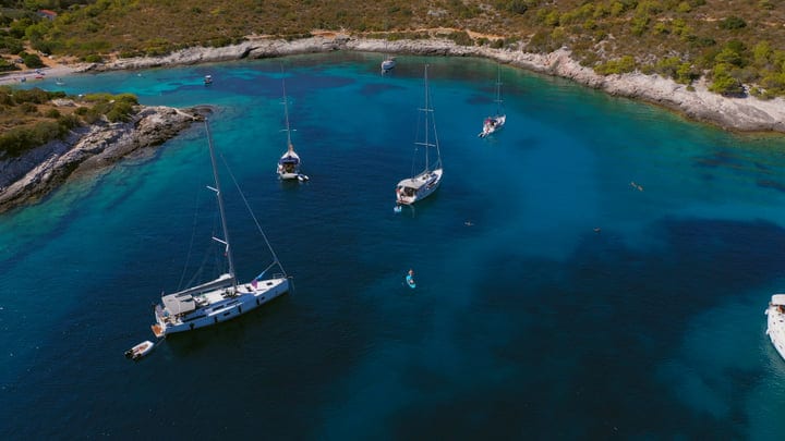 Sailboats Gently Drift In A Serene Turquoise Bay