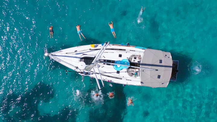 Joyful Plunge into Turquoise Waters from a Sailboat