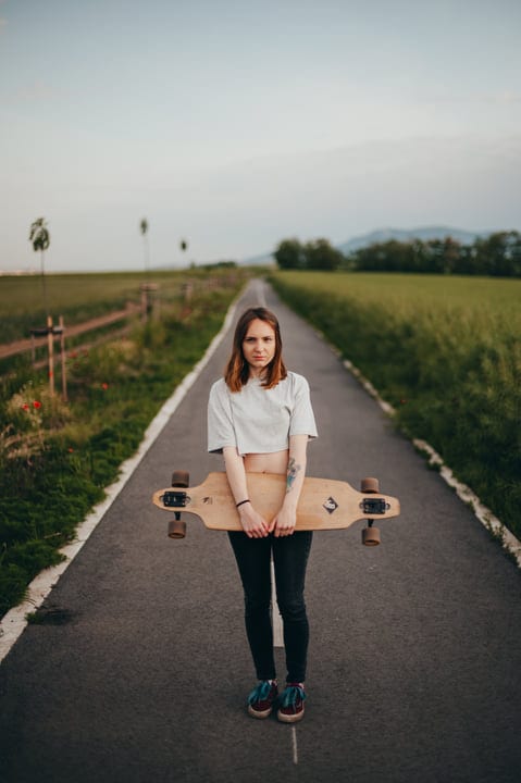 Young Skateboarder Embraces Freedom On A Country Road