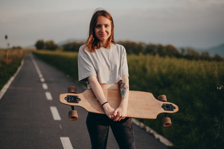 Sunlit Country Road Adventure With A Skateboarder