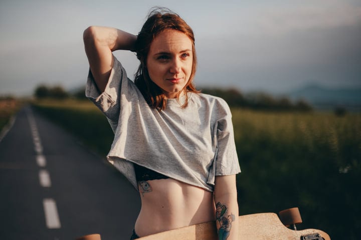Sunlit Skater Pauses On A Serene Country Road
