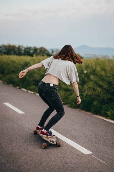 Skateboarder Glides Gracefully Down A Scenic Country Road