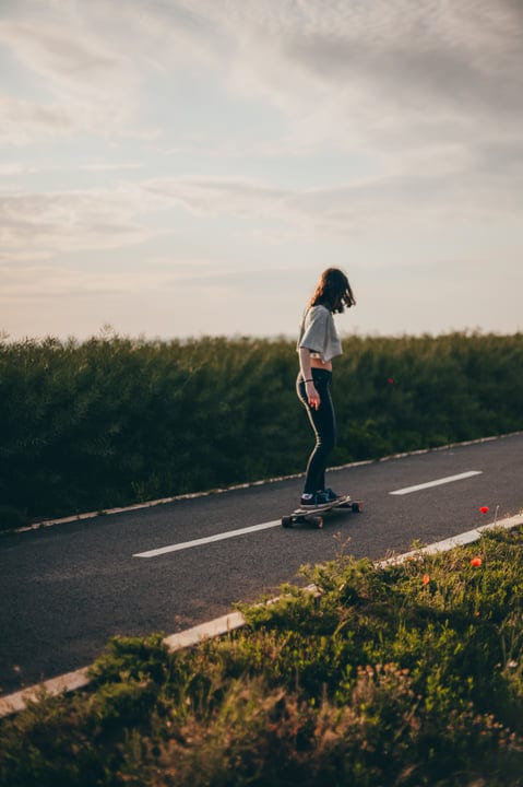 Skateboarder Glides Down a Serene Country Road at Dusk