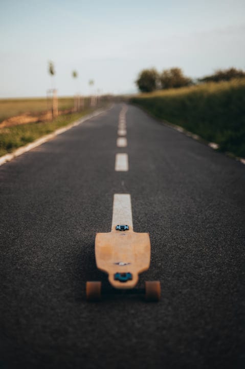Skateboard Awaits Adventure On A Serene Country Road