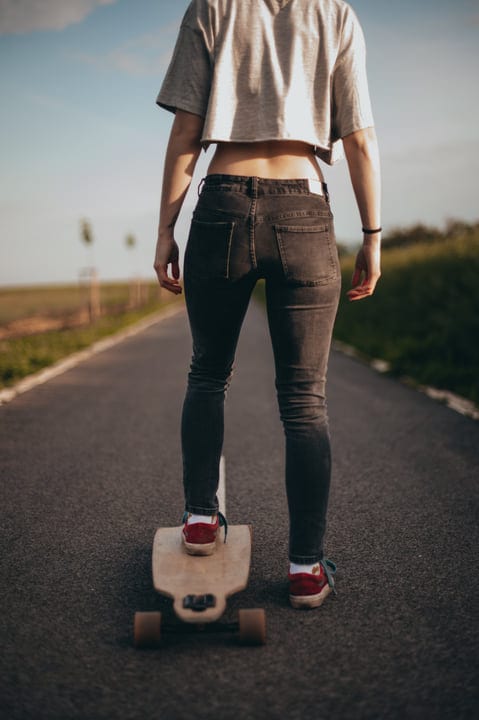 Young Skateboarder Glides Freely Along a Serene Country Road