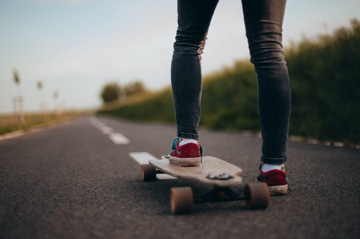 Skateboarder Glides Effortlessly Down A Scenic Country Road