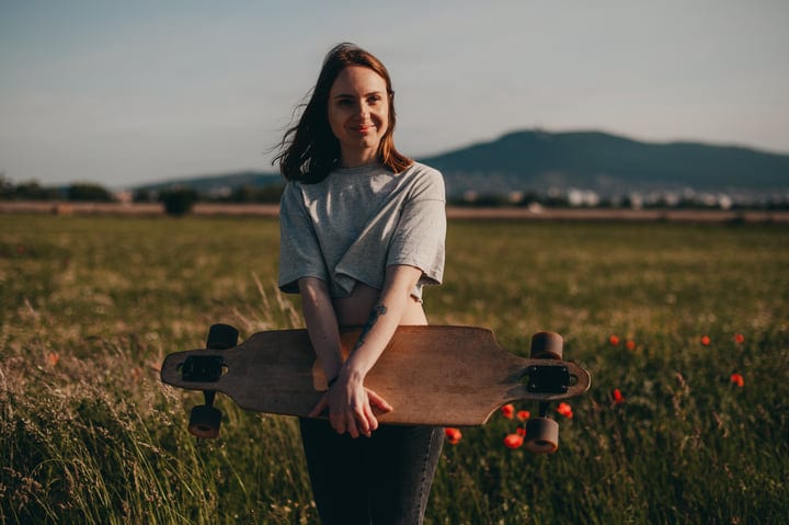 Young Woman Embraces Freedom With Her Skateboard Outdoors