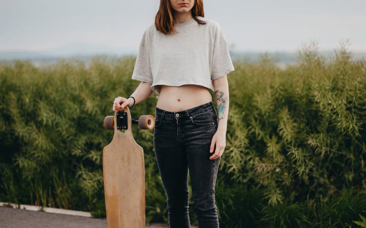 Young Skateboarder Embraces Nature On A Country Road