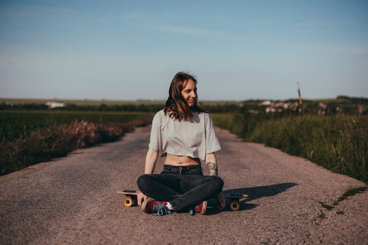 Young Woman Enjoying Serenity On Her Skateboard Journey