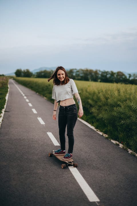 Young Woman Gliding Effortlessly Down A Country Road