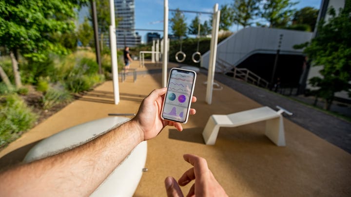 Checking Fitness Progress In The Urban Park Sunset