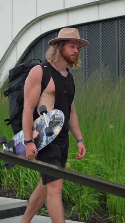 Skater Walks With Board At Urban Sunset