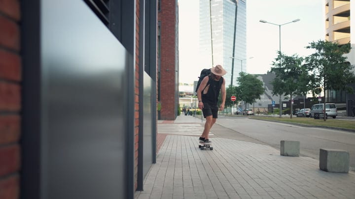 Skater in a Straw Hat Gliding Through Urban Streets