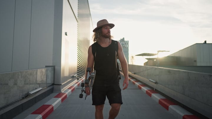 Skater Strolls Through Urban Rooftop at Sunset
