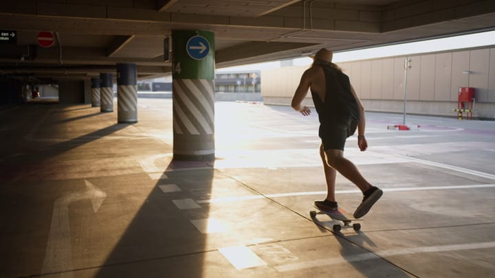 Skater Glides Through Sunlit Parking Lot at Dusk