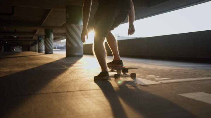Skater Gliding Through a Sunlit Urban Parking Garage
