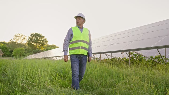 A Solar Engineer Surveys Panels Under Evening Light