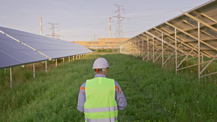 Engineer Inspects Solar Panels Under Morning Light