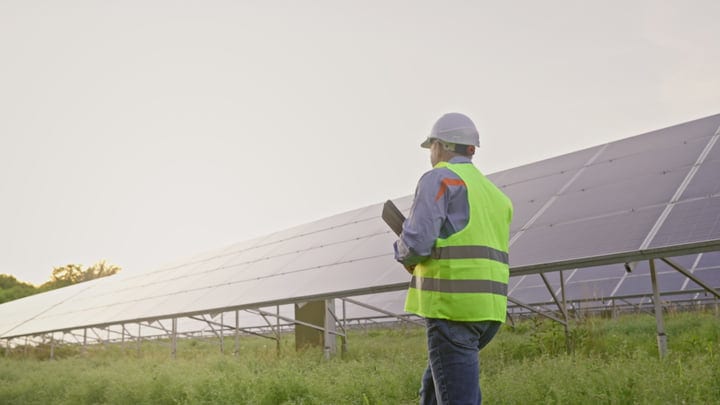 Engineer Conducts Detailed Solar Panel Inspection At Dawn