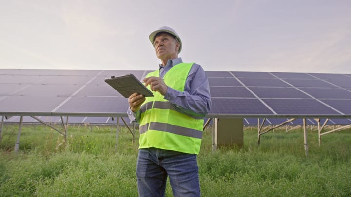 Engineer Conducts Solar Panel Inspection At Dusk