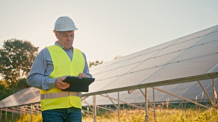 Engineer Reviews Solar Panels Under Golden Evening Light